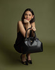 Bolso tipo bowling en piel color negro y clip al centro con asas al hombro para mujer