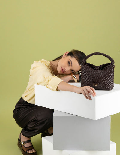 Minibolso café en piel vegana trenzada con logo dorado para mujer