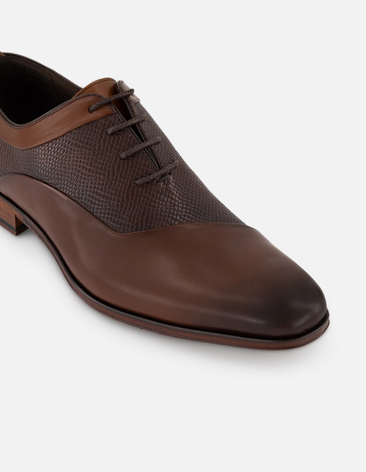 Zapato Inglés café de piel con grabado tipo serpiente asimétrico