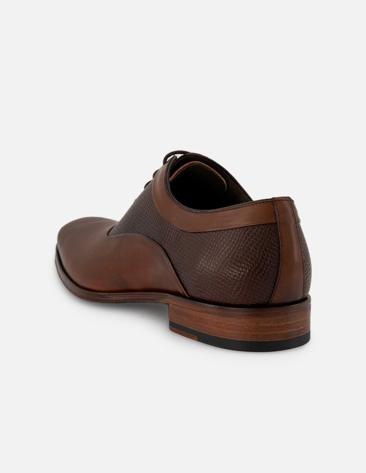 Zapato Inglés café de piel con grabado tipo serpiente asimétrico