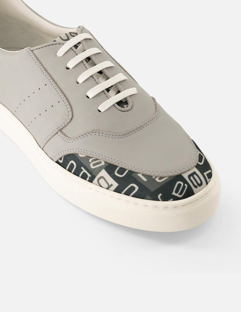 Tenis en piel napa color gris con textil de letras Prada para hombre